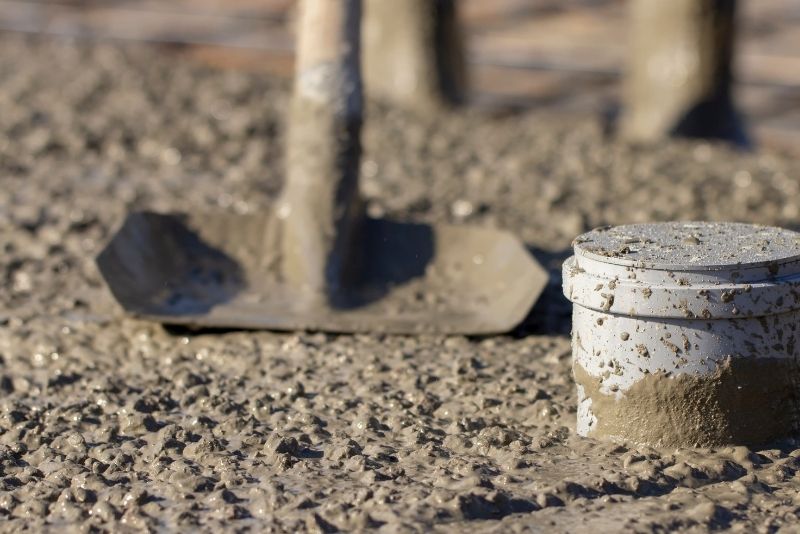 a picture of a concrete mixture, a shovel and a can