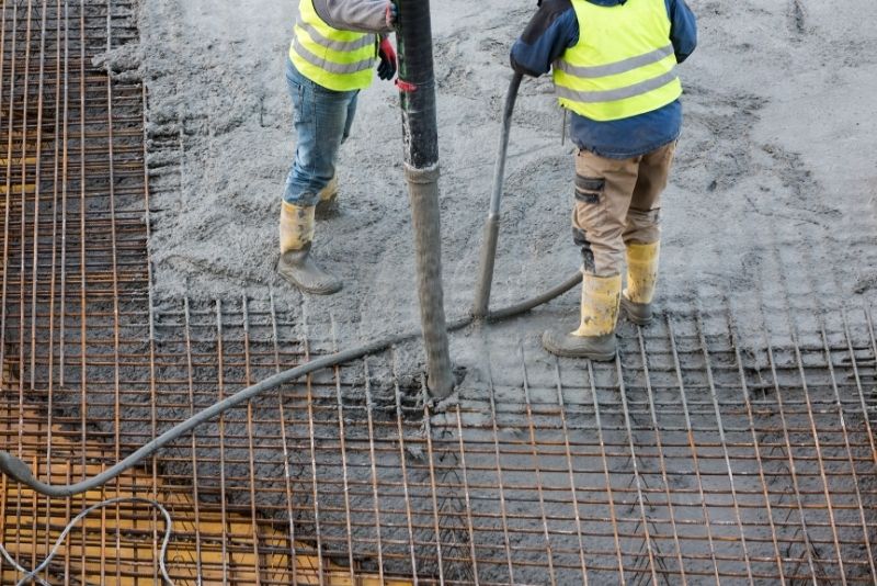 expert concreters pouring concrete mix on the building